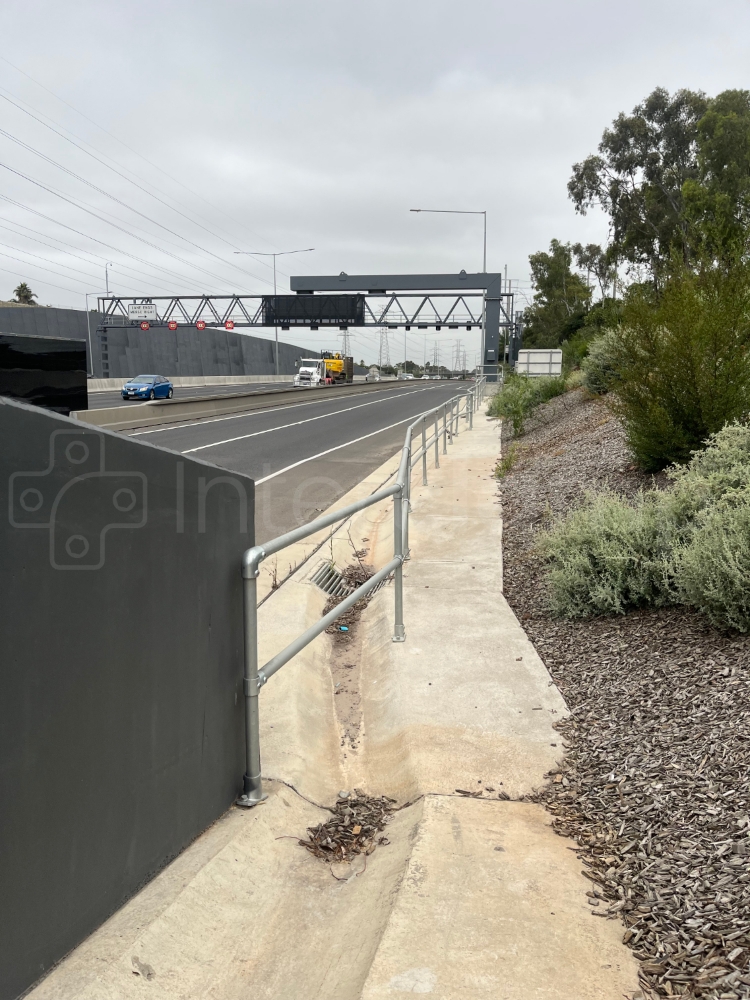 Modular galvanised key clamp handrail barrier constructed next to a highway